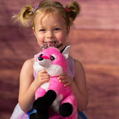 girl holding 10 in stuffed pink fox with bow and pink glitter eyes