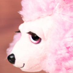 stuffed 10 in pink poodle with pink glitter eyes and eyelashes wearing a bow