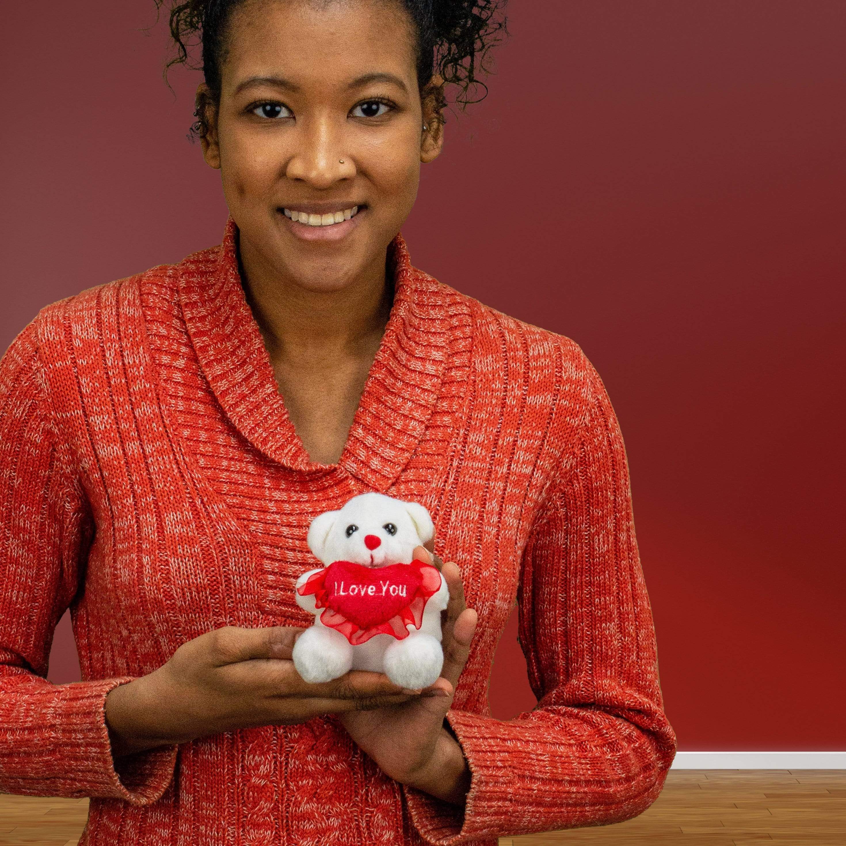 A woman holds a white bear that is 4 inches tall while sitting holding a red I LOVE YOU heart