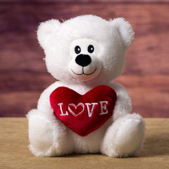 A white bear that is 9.5 inches tall while sitting holding a red Love bear